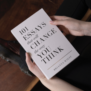 Two hands holding a book named 101 essays that will change the way you think